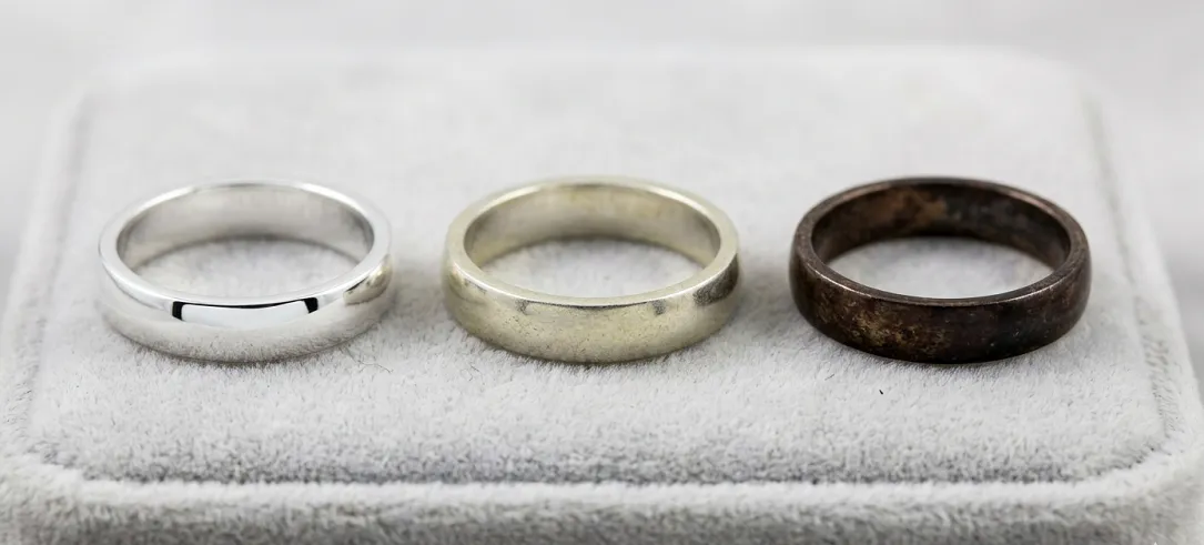 Three sterling silver rings showing light, moderate, and heavy tarnish levels side by side