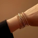 Woman's wrist wearing stacked gold and silver bracelets to show mixed metal jewellery styling